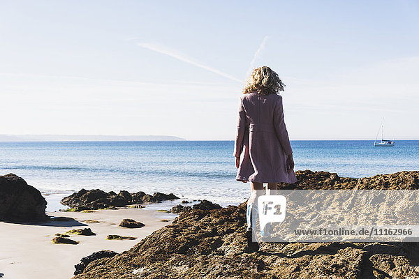 Frankreich  Halbinsel Crozon  Teenager-Mädchen auf dem Felsen am Strand