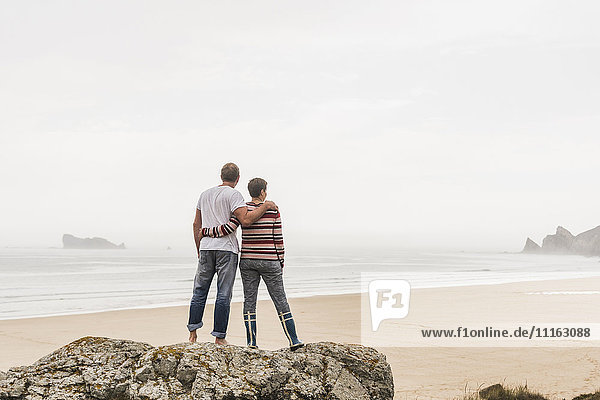 France  Bretagne  Crozon peninsula  couple standing on rock at the beach