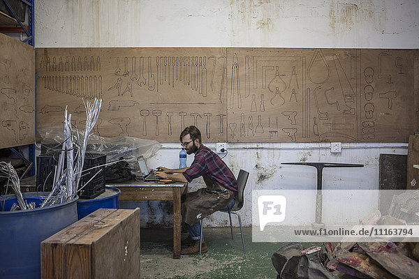 Man in workshop using laptop