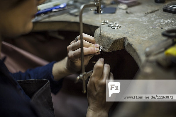 Goldsmith working on jewelery in workshop
