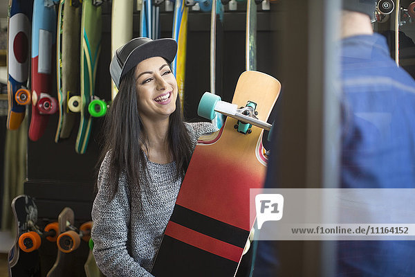 Junge Frau beim Einkaufen für ein Skateboard