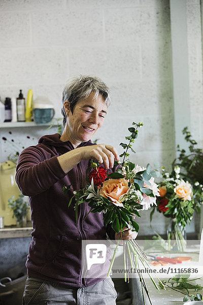 Organische Blumenarrangements. Eine Frau kreiert einen handgebundenen Blumenstrauß.