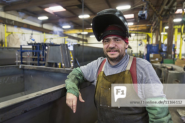 Caucasian welder posing in factory