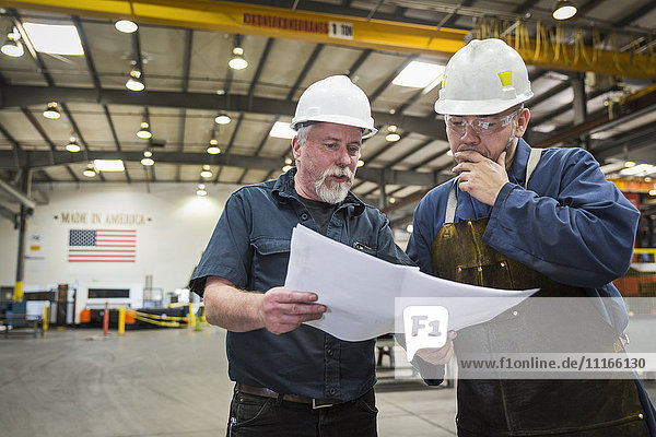 Arbeiter prüfen Papierkram in der Fabrik