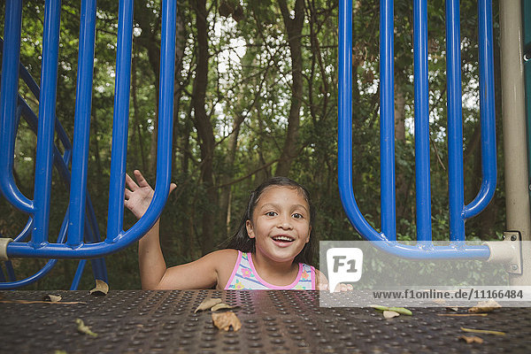 Lächelndes hispanisches Mädchen auf dem Spielplatz
