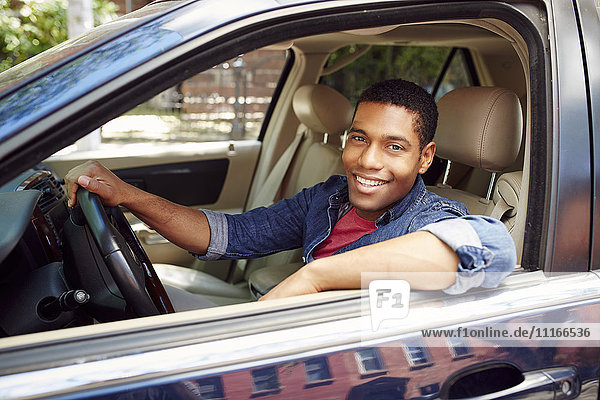 Lächelnder Mann posiert im Autofenster