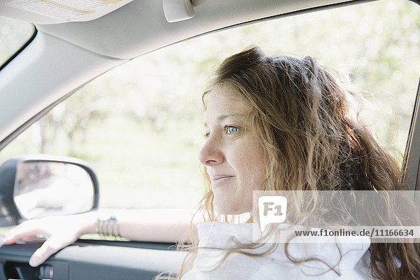 Frau  die auf dem Vordersitz eines Autos sitzt.