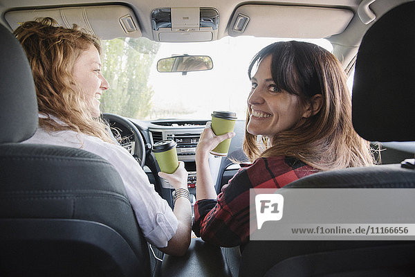 Zwei Frauen in einem Auto auf einer Autoreise. Blick von hinten.