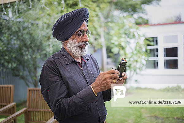 Indian man texting on cell phone
