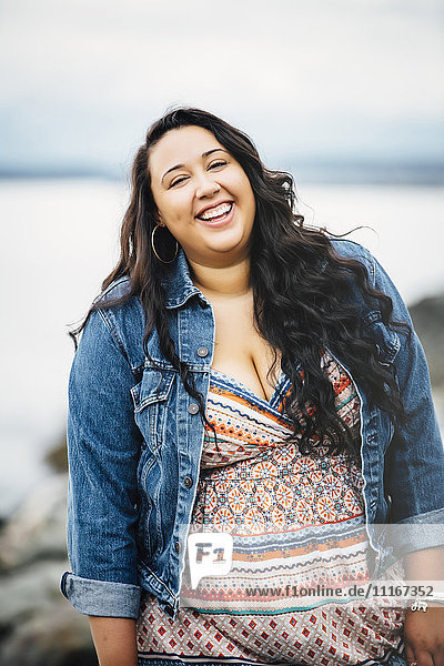 Lächelnde Mixed Race Frau in der Nähe des Ozeans