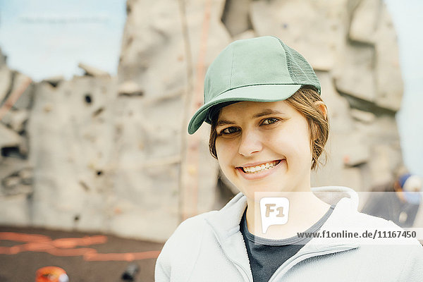 Kaukasische Frau lächelnd in der Nähe einer Kletterwand