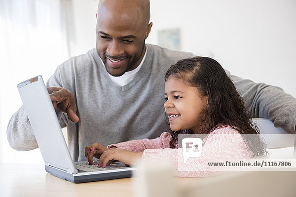 Vater und Tochter benutzen Laptop
