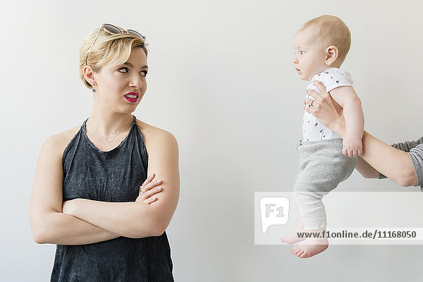 Caucasian woman disgusted at woman offering baby