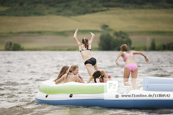 Teenager-Mädchen in einem Schlauchboot auf einem See.