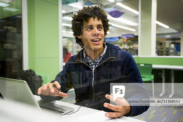Mixed Race student using laptop in library