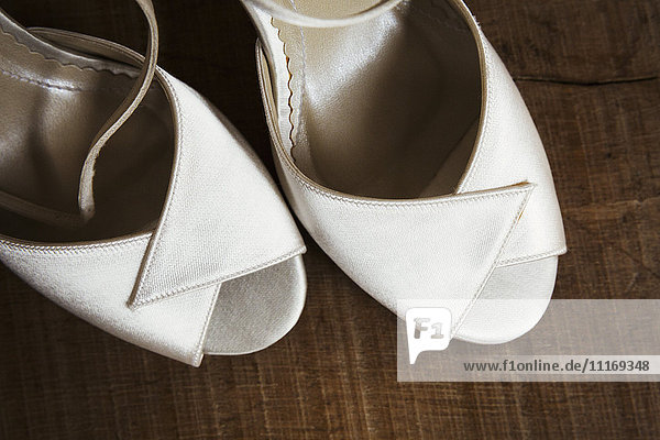 Ein Paar weiße Schuhe mit Piepens-Zehenspitzen. Nahaufnahme der Hochzeitsschuhe.