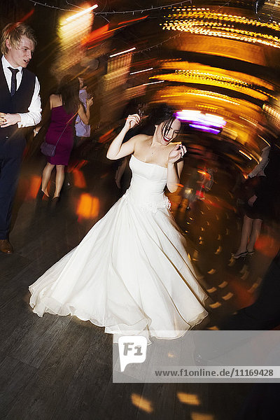 Eine Braut tanzt auf ihrer Hochzeitsfeier.