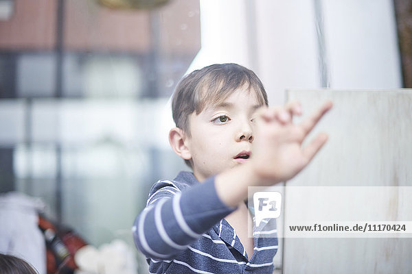 Hispanic boy touching window