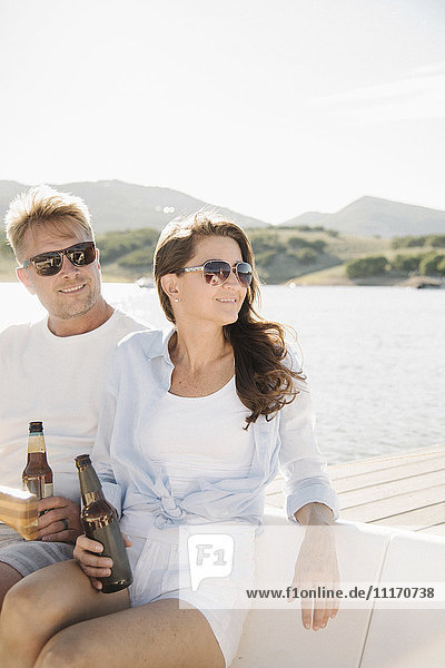 Man and woman on a sail boat  having a drink.