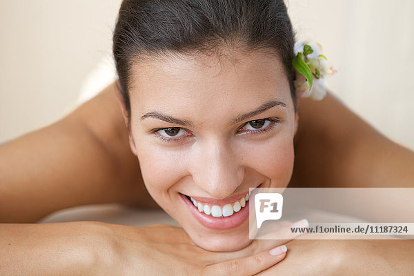Close-up of cheerful young woman relaxing on massage table