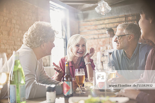 Paare  die sich am Restauranttisch unterhalten und Bier trinken