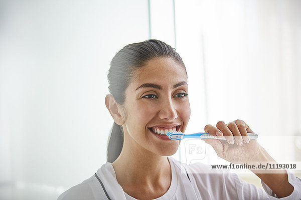 Woman brushing teeth with toothbrush