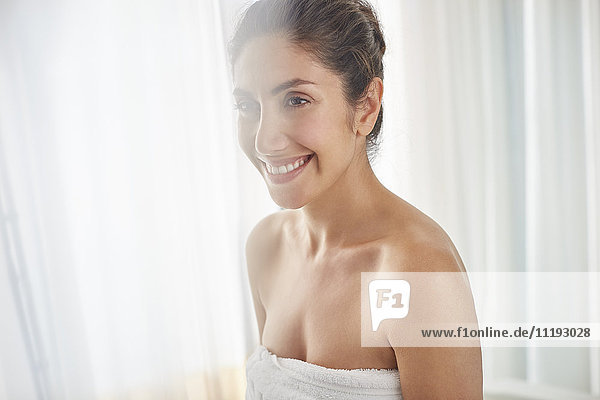 Smiling woman wrapped in towel
