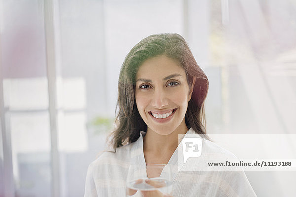 Porträt lächelnde brünette Frau trinkt Wasser