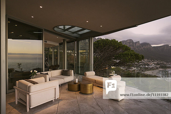 Reflexion der Dämmerung Blick auf den Ozean auf modernen Luxus Hause Showcase Terrasse mit Blick auf die Berge