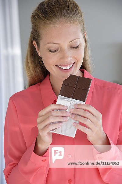 Close-up of a woman eating chocolate bar