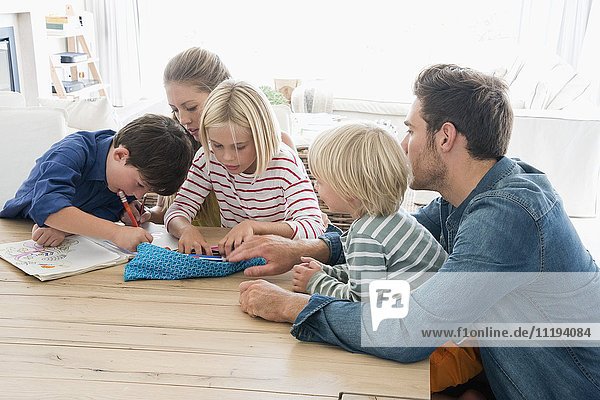 Eltern und Kinder bei den Hausaufgaben auf dem Tisch