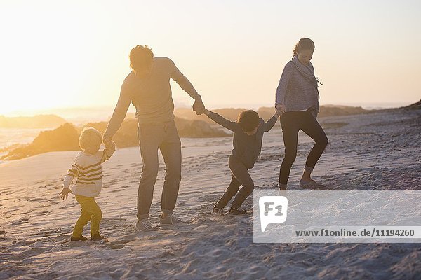 Parents with their children walking on the beach