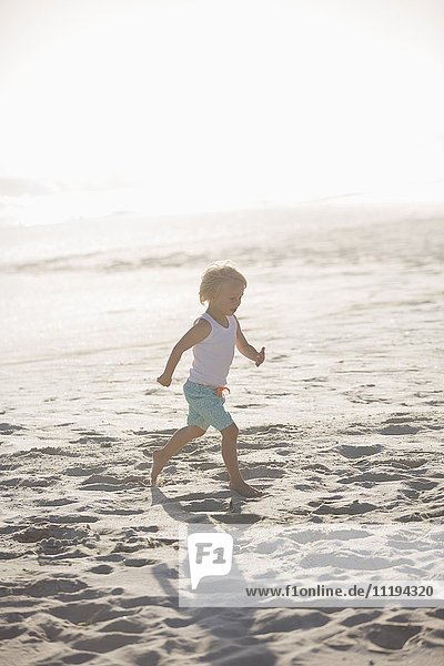 Profile of a boy running on the beach