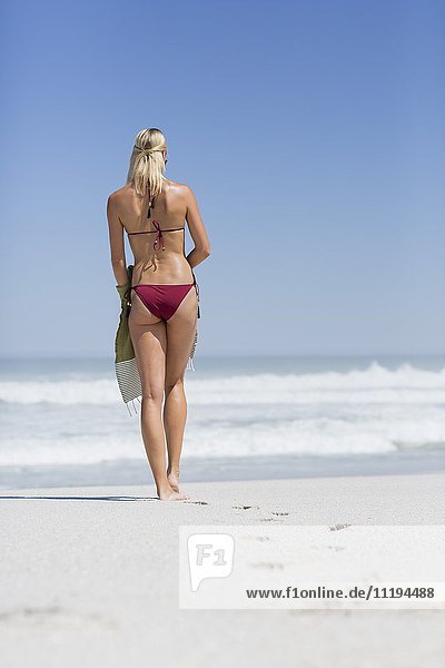 Schöne Frau  die am Strand spazieren geht.