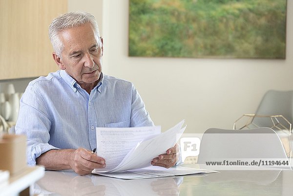 Senior man doing paperwork at home