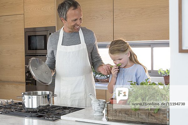 Kleines Mädchen und ihr Vater bereiten das Essen in der Küche zu.