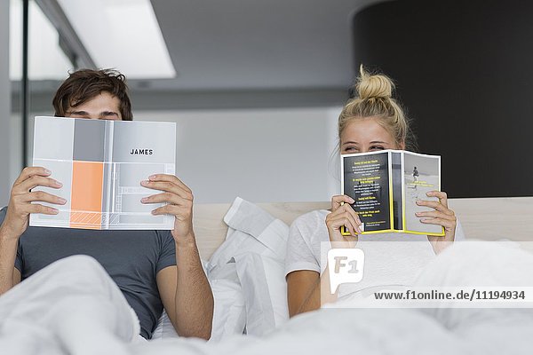 Young couple reading books on the bed