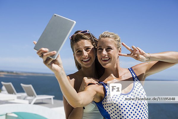 Attraktive Freundinnen  die sich mit einem digitalen Tablett selbst verwöhnen lassen