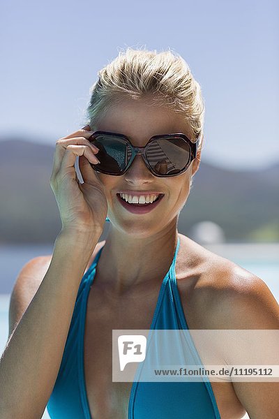 Nahaufnahme einer glücklichen jungen Frau mit Sonnenbrille