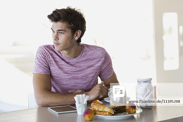 Nahaufnahme eines jungen Mannes beim Frühstücken