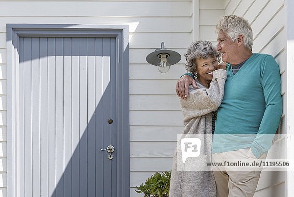 Romantisches Seniorenpaar  das sich außerhalb des Hauses umarmt