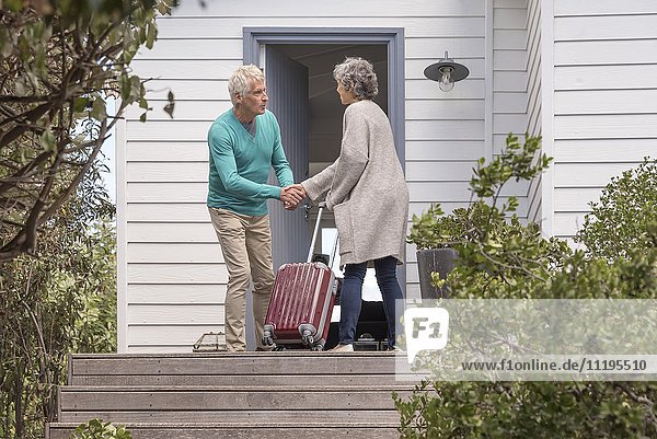 Senior Mann begrüßt Frau am Eingang