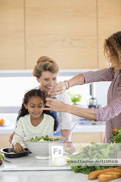 Senior woman with daughter and granddaughter preparing food in kitchen