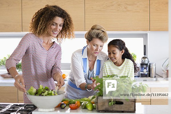 Senior woman with daughter and granddaughter in kitchen