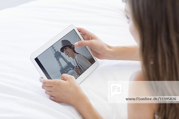 Frau betrachtet Foto auf digitalem Tablett