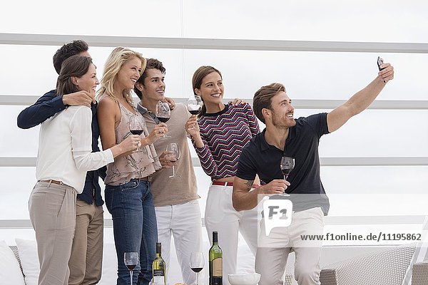 Group of friends taking selfie together at party