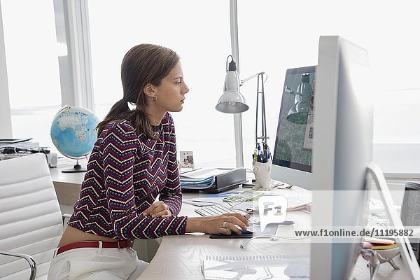 Side profile of a businesswoman working on a desktop pc in office