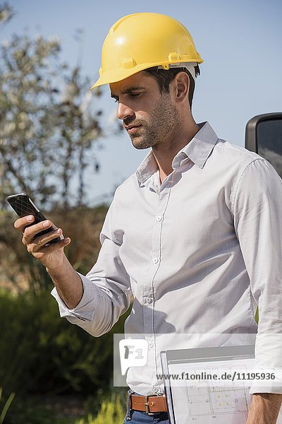 Male engineer using a mobile phone at site