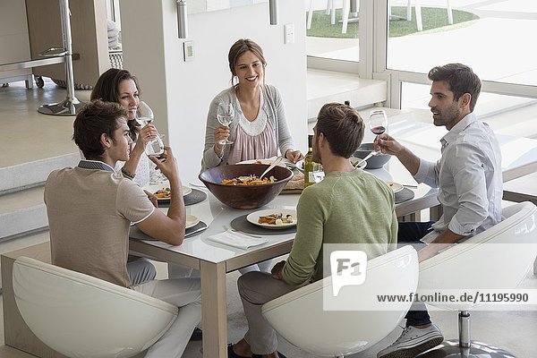Group of happy friends having lunch at dining table