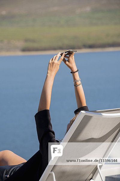 Junge Frau nimmt Selfie mit Fotohandy an der Waterfront